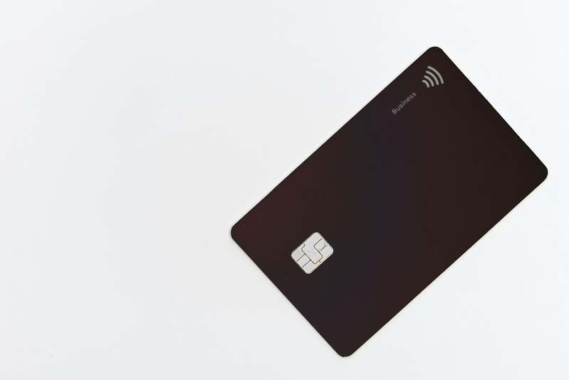 A clean desktop setup showing a credit card, printed receipt, laptop open to a price protection claim form, and a checkmark icon — symbolizing informed, successful price protection claims